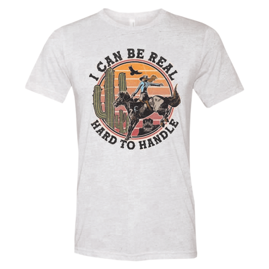 ladies tee-white-"I can be real hard to handle" cowgirl on horse in desert with bird and cactus