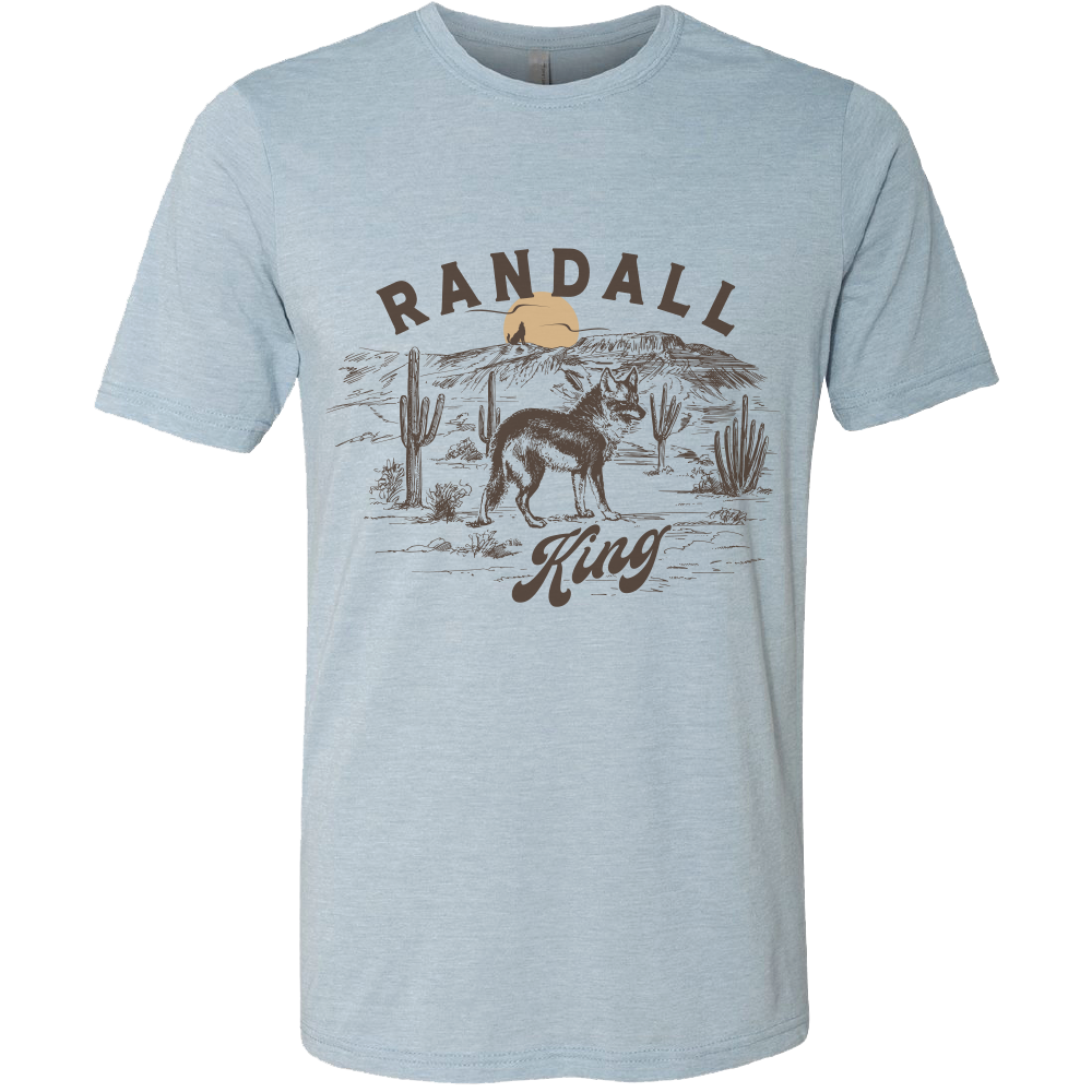 tee-heather light blue-"Randall King" coyote in desert with sunset